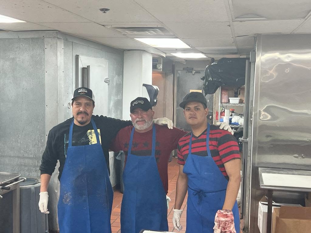 The Guadalajara Meat Market team in aprons behind the counter at the New Braunfels store